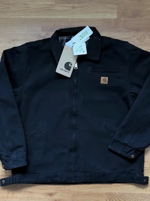 Carhartt jacka - Stilren och perfekt för layering. Säljes pga felstorlek. Mått: längd 67cm, ärm 62cm. Finns även kvitto för den som vill se!