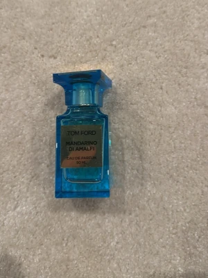Tom Ford Mandarino di Amalfi 50 ml - Tom Ford Mandarino di Amalfi Eau de Parfum i en lyxig, blå glasflaska på 50 ml. Flaskan har en elegant, fyrkantig form och en matchande blå kork. Doften är inspirerad av italienska citrusnoter och ger en fräsch och exklusiv känsla.