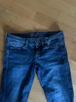 Mörkblå bootcut jeans från Guess - Snygga mörkblå lågmidjade bootcut jeans från Guess 💕 utsydda till bootcut längst ner med maskin och säljer för de inte passade mig! Ganska långa i benen
