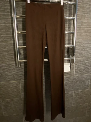 Bruna ribbade leggings från H&M Divided - Säljer ett par bruna ribbade leggings från H&M Divided i storlek XS. De har utsvängda ben och är tillverkade i ett stretchigt material som sitter skönt. 