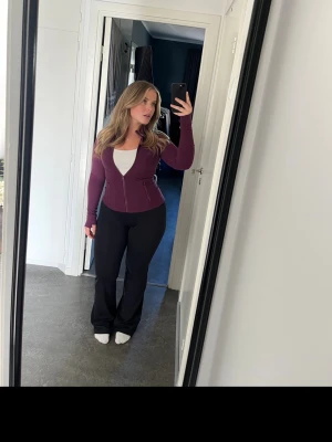 Vinröd träningsjacka  - Snygg vinröd långärmad topp med dragkedja framtill och hög krage. Modellen är slim och har två fickor med dragkedja. Den första bilden visar den riktiga färgen💜