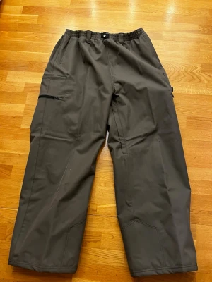 Capeesh decpant mörk grå XL - Säljer dessa capeesh byxor som är helt nya med lappen kvar. De är perfekta för dig som vill ha de fetaste byxorna i skidbacken!                                         Vid frågor eller funderingar hör gärna av er 😁