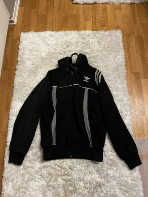 Vintage svart adidas hoodie  - Svart adidas hoodie, med drag kedja. Lite sönder vid hand lederna men annars jätte bra. Priset kan diskuteras. 