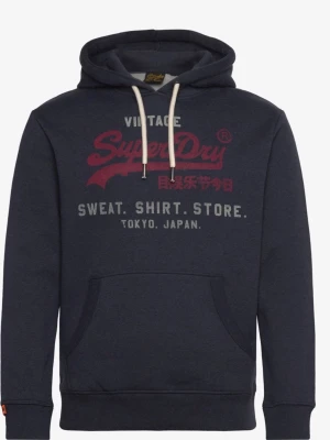 Mörkblå Superdry hoodie med tryck - Mörkblå hoodie från Superdry med stor röd och vit logga på bröstet samt japansk text. Klassisk känguruficka framtill och vita dragsnören i huvan. Mjuk insida och ribbade muddar vid ärmar och nederkant. Perfekt för en avslappnad streetwear-look.