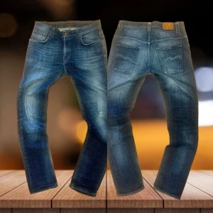 Nudie denim archive washed jeans  - Sjukt feta nudie denim jeans i den eftertraktade marinblå färgen som passar till allt. Jeansen har ens del tvätt längst benen och är mycket bra skick med endast en liten skavank på högre knä. Jeansen är i storlek 32/32 men passar dig bra som brukar ha 31 eller 30 också. JAG KAN INTE TA BILD MED PÅ. Bara att skriva vid minsta fundering! 