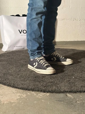 Converse One Star svarta låga sneakers - Klassiska Converse One Star sneakers i svart canvas med vita detaljer och stjärnlogga på sidan. Lågt skaft, vita snören och tåhätta i gummi. Yttersula i gummi med mönster för bra grepp. Perfekta för en avslappnad streetwear-look.    Storlek 44/ knappt använda 