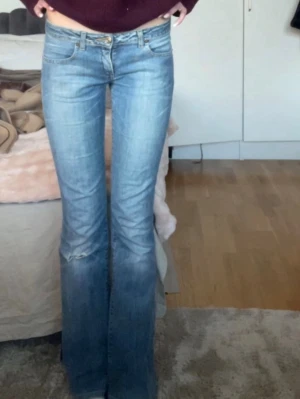 Lågmidjade bootcut jeans  - Lågmidjade bootcut jeans med ett hål på låret. Knappen är lite lös men går att sy fast. Midjemåttet är 36 cm rakt över & innerbenslängden är 83 cm. Jag är 175 😊