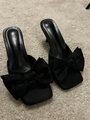 Klackar med rosett - Svarta klackar i storlek 38 men passar nog 37 ganska små i storlek aldrig använda 