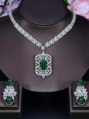 Lyxigt halsband med gröna stenar - Säljer ett riktigt statement halsband med gnistrande klara stenar och en stor, rektangulär grön sten i mitten. Halsbandet har en elegant design med många små, klara stenar som bildar ett mönster runt den gröna stenen. Perfekt för dig som vill sticka ut och älskar glam. ( I kopparmaterial). Lyxig smyckelåda medföljer