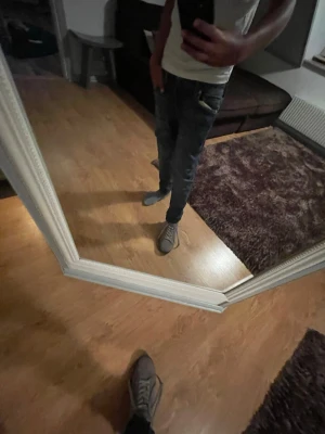 Christian Louboutins - Säljer ett par grå sneakers i mocka med svart sula och cool röd undersida. Skorna har snörning och en stilren, låg profil som passar till jeans eller shorts. Perfekta för dig som vill ha en clean look med en twist. Sköna att gå i och riktigt snygga detaljer.