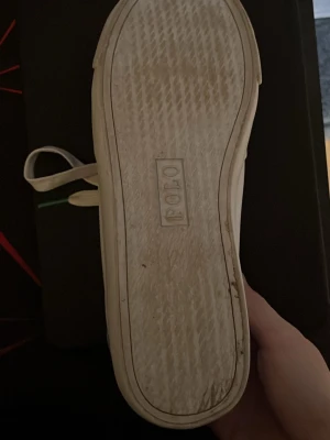 Vita Polo Ralph Lauren sneakers - Snygga vita sneakers från Polo Ralph Lauren med klassisk låg profil och gröna detaljer. Skorna har vita snören, rund tå och Polo-logga på plösen samt yttersulan. Tillverkade i slittåligt material med stilren design.