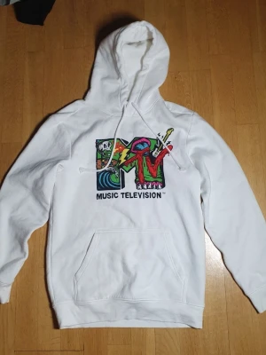 MTV Huvtröja / Hoodie | XS / Extra Small - Skön huvtröjja med färglatt MTV (Music Televison) tryck på framsidan.  MTV X HM (2022). Extra Small (Mått finns på bilderna!) 57% bomull. 43% polyester. Noppor förekommer, men går nog lätt bort med en noppborttagare.  Se bilder.