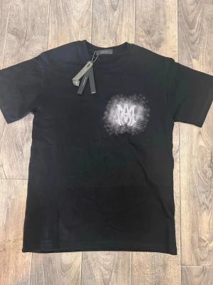 Svart t-shirt med tryck - Svart t-shirt från Amiri med ett coolt grafiskt tryck i vitt på bröstet. Klassisk rund halsringning och korta ärmar. 
