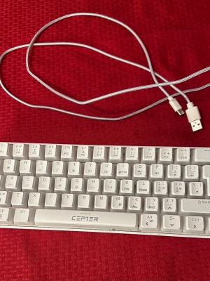 Cepter Athena bakgrundsbelyst  gamingtangentbord  - Säljer ett vitt tangentbord från Cepter  med USB-anslutning och avtagbar kabel. Tangentbordet har kompakta tangenter och passar perfekt till datorn eller gaming. Kabeln är vit och har både USB och USB-C kontakt. Snygg och stilren design i plast.
