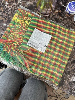 Randig halsduk i rasta-färger - Färgglad halsduk med ränder i grönt, gult och rött. Halsduken har fransar i ändarna och är tillverkad i ett mjukt, vävt material. Perfekt för dig som vill sticka ut med en unik accessoar.