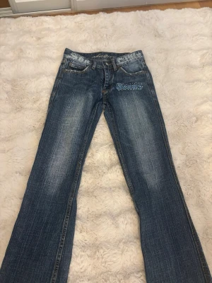 Lågmidjade utsvängda jeans Shaqiru - JÄTTE snygga lånmidjade jeans från Shaqiru älskar dessa jeans men när jag köpte dom och dom kom hem var dom försmå i mina lår och midja derför säljer jag dom en av bilderna visar att dom har gått sönder lite där man sätter fast bältet och de hände när jag skulle ta på mig dom men de inget som syns jätte tråkigt att jag behöver sälja dessa men hoppas dom kommer till användning