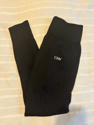 Svarta define seamless leggings från ICANIWILL - Svarta seamless leggings från ICANIWILL med hög midja och diskret logga på låret. Stretchigt material som sitter tight och bekvämt. Perfekta för träning eller chill. Klassisk svart färg som passar till allt.