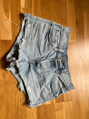 Levis 501 jeansshorts - Jeansshorts från Levis, modell 501. Strl 26. Midjemått tvärsöver ca 34 cm enligt bild. 