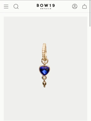 ZOE EARRING - Säljer ett par söta örhängen från BOW19 i guldfärg med blå hjärtformade berlocker. Perfekta för att liva upp en basic outfit och extra fina till blåa ögon! Ett par kostar 198 kronor på hemsidan.