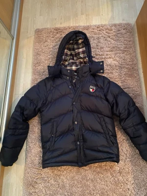 LIMITED EDITION hilfiger jacka - As snygg mörkblå hilfiger jacka. Den är storlek M och sitter bra och skönt. Den har lite defekter men de flesta är svåra att se och märks inte av. Den är limited edition och jag säljer den för ett väldigt lågt pris. Hör gärna av vid frågor!