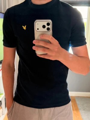 Marinblå t-shirt från Lyle & Scott - T-shirt från Lyle & Scott i stickat material med klassisk relaxed fit och korta ärmar. 
