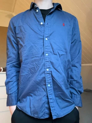 Blå skjorta från Ralph Lauren - Säljer denna Ralph Lauren skjortan i storlek S. Modellen är 175 och väger 65kg.  Skriv vid frågor