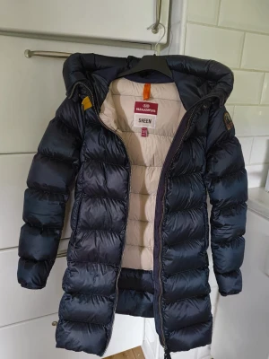 Mörkblå dunjacka Parajumpers Sheen - Snygg mörkblå dunjacka från Parajumpers i storlek xxs. Den är använd men i bra skick. Dock har jackan två jättesmå hål som är lagade. Det syns på bilderna. Pris kan diskuteras.