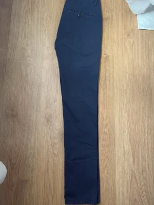 Mörkblå Dondup chinos - Fina Mörkblå Dondup chinos i storleken 30. Sparsamt använda och i grymt skick. Tagg / lapp med dondup medföljer vid köp.                                       Tveka inte på att höra av dig vid funderingar!