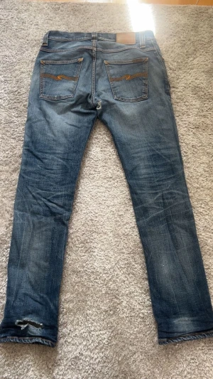 Vintage Nudie Jeans - Tjena! Säljer nu ett par sjukt najs nudie som har fått sjuka fades och slitningar. Storlek w31, l32.  Jeansen har ett litet hål i skrevet (bild 3) men som går att laga gratis hos nudie om man vill! Fade har det blivit på jeansen av 10+ års försiktig användning så mycket vintage, priset är ej hugget i sten så hör av er vid frågor🔥😁