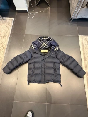 Mörkblå dunjacka från Burberry - Säljer en sjukt sällsynt Butberry jacka som man kan göra till en väst! Storlek 48! Hör gärna av dig om du har frågor!
