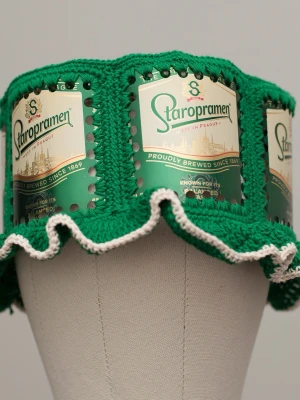 Virkad ölhatt Staropramen - Unik virkad ölhatt med Staropramen.   Virkad i 100% bomull. Passar upp till ca 60cm.  Vissa burkar kan ha mindre repor eller bucklor, vilket tyvärr kan uppstå under tillverkningen av hattarna. Insidan av burkarna slipas efter hålen tagits för att undvika vassa kanter. Därför kan det ibland finnas lite slipmärken, men det är inget som stör eftersom det är på insidan av hattarna.  Färger kan variera något beroende på skärminställningar.