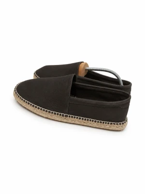 Bruna  loafers med flätad sula - Säljer ett par stilrena svarta loafers med rundad tå och klassisk slip-on design. Skorna har en snygg flätad sula i naturfärgad jute som ger en avslappnad vibe. Ovandelen är i svart tyg och sömmarna är markerade i kontrastfärg. Perfekta för en chill och trendig look.