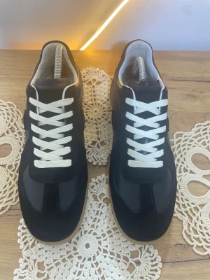 Svarta Maison Margiela - Helt nya svarta Maison Margiela-skor, oanvända och i toppskick. Storlek [43]. Säljes för [1699]. Hör av dig om du vill ha fler bilder eller mer info!🥂 