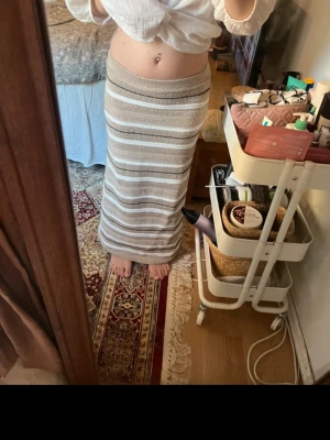  randig långkjol från Zara  - Säljer en långkjol med beige och vita ränder från Zara . Kjolen har en rak passform och är stickad i ett mjukt material som känns skönt mot huden. Perfekt för dig som gillar en avslappnad men ändå stilren look. Den är använd men i fint skick🍓☀️