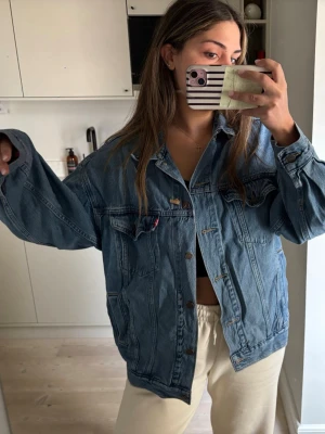 Oversize blå jeansjacka från Levi's - Oversizes jeans jacka från Levis, lite skrynklig på bilden då den legat k förråd och behöver strykas