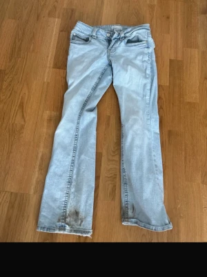 Ljusblå bootcut jeans från Perfect Jeans - Säljer ett par ljusblå bootcut jeans från Perfect Jeans i storlek 36. Klassisk femficksmodell med knapp och dragkedja framtill. Jeansen har en avslappnad passform och är tillverkade i denim med lätt tvättad look.
