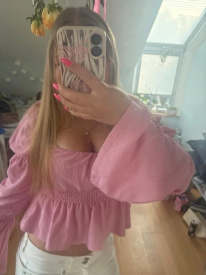 Rosa blus - Supersöt rosa blus med vida långa ärmar och smockad midja. Materialet är lätt och luftigt, vilket gör den skön att ha under varma dagar.             Om du undrar något är det bara att fråga!💕