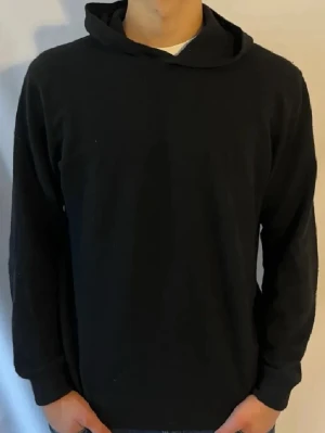 Oscar Jacobson Kashmir hoodie  - En stilren svart hoodie från Jack & Jones med klassisk huva och långa ärmar. Hoodien är enkel i designen utan tryck eller detaljer, perfekt för en clean look. Tillverkad i mjukt material som känns skönt mot huden. L sitter som M