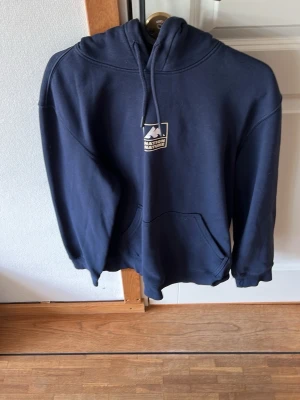 Mörkblå hoodie HM - Säljer en mörkblå hoodie från HM med tryck fram och bak. Hoodien är i fint skick!