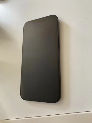 IPhone 13 (85 batteri) - iPhone 13 inga skrapor på skärmen hellt rent och fin inga skador alls på fram och baksidan kameran funkar bra alla knappt funkar inga skador nånstans 64gb Snygg svart med stilren design och rundade hörn. Baksidan är i glas med två stora kameralinser och Apple-loggan i mitten. Telefonen har en modern look och känns riktigt premium i handen. Perfekt för dig som gillar Apple och vill ha en mobil med grym kamera.
