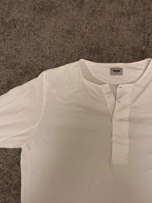  Acne A/W 2010 kollektion henley longsleeve - Snygg vit henley från Acne med rund halsringning och knappslå framtill. Från kollektionen A/W 2010. Passar både gubbar och gummor🤍