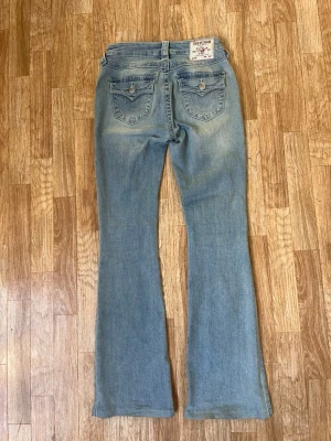Ljusblå bootcut jeans True Religion - Säljer ett par jeans från true religion. Jeansen är i modellen BECCA och i storlek 25 vilket motsvarar xs. Inga defekter!  Hör av er vid några funderingar 😊