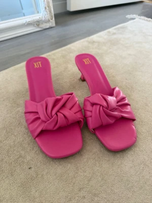 Rosa sandaler med knut från dinsko - Snygga rosa sandaler från dinsko med fyrkantig tå och låg klack. Ovandelen har en trendig knutdetalj i mjukt material som ger en cool look. Perfekta för att lyfta vilken outfit som helst med sin färg och design.