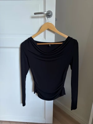 Svart långärmad topp från H&M - Svart långärmad topp från H&M med draperad halsringning och figurnära passform. 