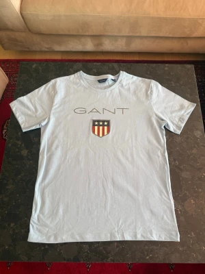 Gant ljusblå t shirt  - Ljusblå gant t shirt i storlek 176/s. Nyskick aldrig använd 