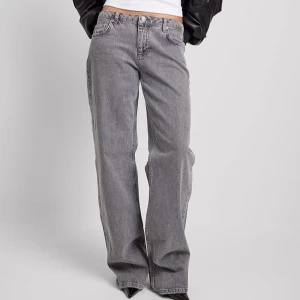 Gråa Jeans med låg midja NA-KD - Supersnygga och trendiga gråa jeans från NA-KD med raka ben och låg midja. (Nypris 699) Bra skick & i storlek 36 men uppsydda ca 4-5 cm. Som ni ser på deras bild (1a) är jeansen rätt långa och de har dessutom klackar. 