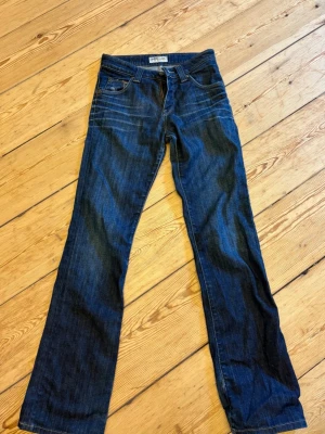 Mörkblå bootcut jeans från Lee - Säljer ett par mörkblå bootcut jeans från Lee med klassiska fickor och låg midja. Jeansen har snygga slitningar och kontrastsömmar. Tillverkade i denim med en skön passform och Lee-logga på bakfickan🙌🏼💗 OBS! Är osäker på storleken men skulle gissa att det är str 36