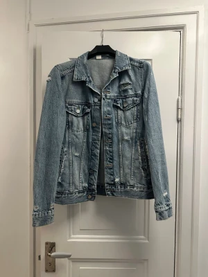 Ljusblå  jeansjacka - Snygg ljusblå jeansjacka i oversized modell med slitna detaljer. Knappt använd 