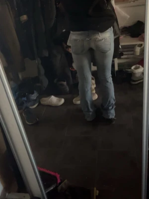Ljusblå bootcut jeans med slitningar - Säljer ett par ljusblå bootcut jeans med slitningar på knäna och detaljerade bakfickor. Jeansen har låg midja🩷xs-s