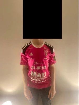 Falun IBF matchtröja rosa Adidas - Säljer en rosa matchtröja från Falun IBF med vita och svarta detaljer. Tröjan har flera tryckta loggor och sponsorer, rund halsringning och korta ärmar. Tillverkad i funktionsmaterial som passar perfekt för innebandy eller träning.